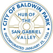 A circular logo featuring the text "CITY OF BALDWIN PARK" prominently displayed at the top. The words "HUB OF THE INCORPORATED SAN GABRIEL VALLEY" are arranged beneath, with the date "RATED 25, 1956" at the bottom. The design includes various stylized elements and is characterized by a bold font.