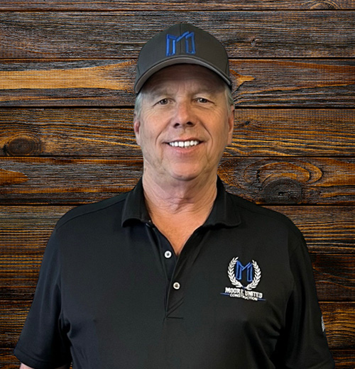 This is an image of Marc Bishop, a consultant associated with Moore United Consulting. The photo includes his name, title, and email address: Marc.Bishop@MooreUnited.com. The design features a transparent background and a dark blue text box displaying his details. He is wearing a black Moore United polo shirt and matching cap with the company logo.